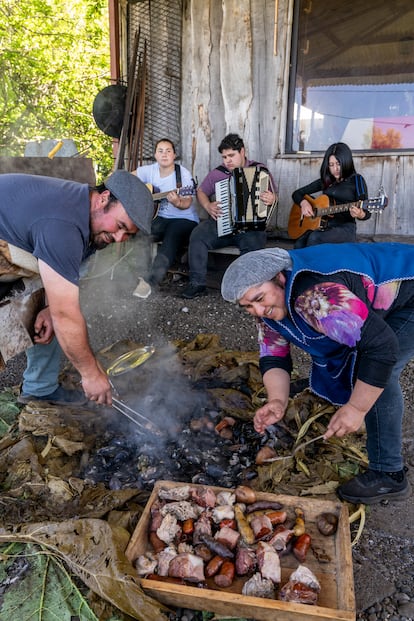 Preparación de un 'curanto', un plato que se elabora en un hoyo cavado en la tierra, en el que se colocan piedras calientes y, sobre ellas, mariscos y carnes, todo ello sellado con hojas de nalca.