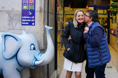 El dueño y una empleada del establecimiento de lotería donde ha tocado el segundo premio del sorteo de El Niño celebran en la calle Arenal en Madrid. 