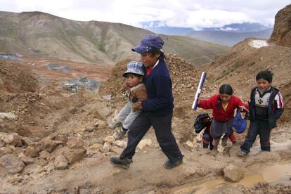 Un grupo de niños acceden desde su casa, situada en la entrada de la mina, al camino para ir a la escuela.