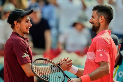 Arnaldi y Djokovic se saludan en la red tras el partido de este sábado en la pista Manolo Santana, en la Caja Mágica (Madrid).