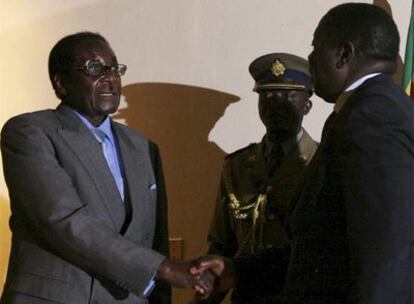 El presidente de Zimbabue, Robert Mugabe, y el líder opositor, Morgan Tsvangirai, se dan la mano hoy en Harare