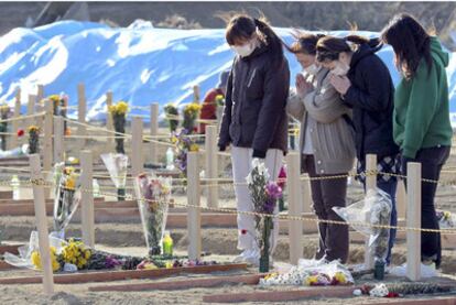 Supervivientes del tsunami rezan para las víctimas, en Miyagi, en el noreste de Japón.