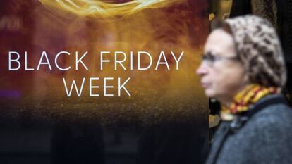 Una mujer pasa ante un escaparate en Londres que anuncia el Black Friday.