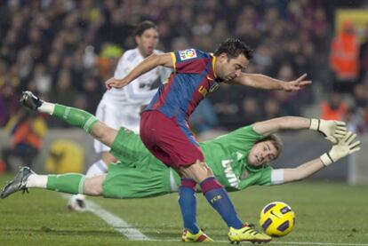 Xavi Hernández trata de superar la salida de Iker Casillas, ante la mirada de Sergio Ramos, el 29 de noviembre de 2010.