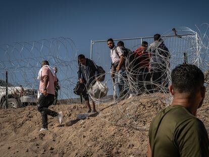 Cientos de migrantes esperan cerca del muro fronterizo, después de cruzar el Río Bravo, en Ciudad Juárez, para entregarse a la patrulla fronteriza de Estados Unidos, el pasado mes de mayo.