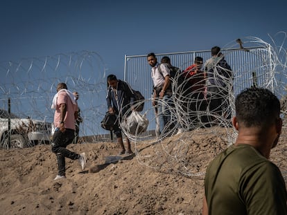 Cientos de migrantes esperan cerca del muro fronterizo, después de cruzar el Río Bravo, en Ciudad Juárez, para entregarse a la patrulla fronteriza de Estados Unidos, el pasado mes de mayo.