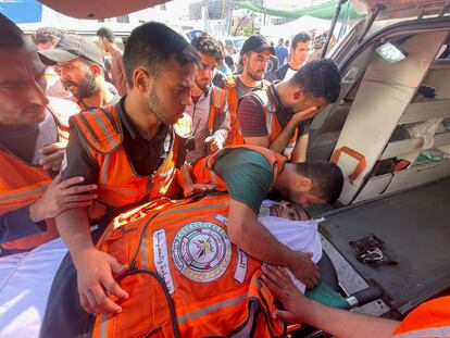 SENSITIVE MATERIAL. THIS IMAGE MAY OFFEND OR DISTURB Members of a Palestinian civil emergency team get emotional near the body one of their colleagues, who was killed in Israeli strikes, at Shifa Hospital in Gaza City October 16, 2023. REUTERS/Mohammed al-Masri
