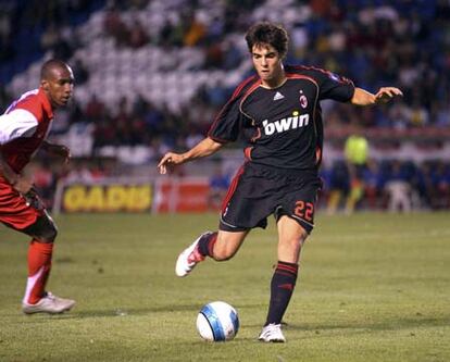 El brasileño Kaká golpea el balón ante la mirada del rojiblanco Perea.