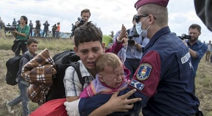 Un policía húngaro bloquea a unos niños refugiados en Röszke (Hungría), el 8 de septiembre de 2015.
