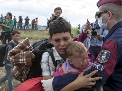 Un policía húngaro bloquea a unos niños refugiados en Röszke (Hungría), el 8 de septiembre de 2015.