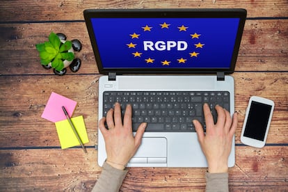 Woman using a computer with Flag of European Union with RGPD word inside on the screen - Protección de datos - Estar donde estés - Banco Sabadell