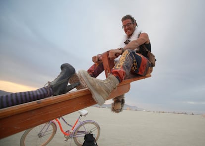 Un participante montado en un 'sube y baja' dentro del festival Burning Man, en Nevada (EE UU).