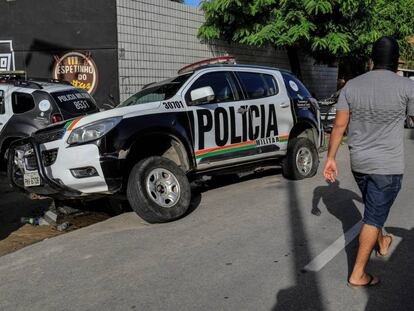 Un encapuchado, supuestamente policía, junto a una patrulla dañada al comienzo de la huelga. 