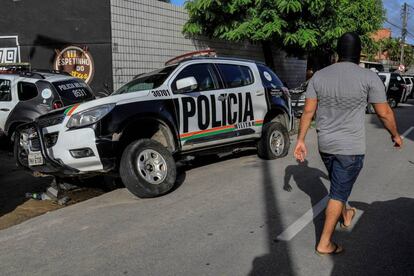 Un encapuchado, supuestamente policía, junto a una patrulla dañada al comienzo de la huelga. 