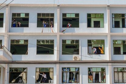 Varias personas limpian un edificio dañado después de un bombardeo en Lashio (Birmania).