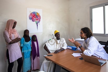 El neurólogo Pedro Rodríguez Cruz informa a Babacar Diaw y sus tres hijas acerca de la enfermedad que sufre la pequeña Soda (en el centro de las tres) en su consulta del hospital de Fann, en Dakar. Diaw, agricultor de 59 años, vive con su familia en el pueblo de Keur Madiabel, en la región senegalesa de Kaolack. Hace un par de años la pequeña comenzó a tener problemas para sujetar cosas. Sufre una enfermedad rara, el síndrome de Brown-Vialetto-Van Laere.