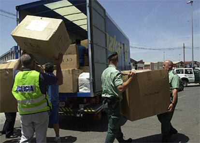 Agentes de la policía y la Guardia Civil cargaban ayer cajas de prendas requisadas en la operación contra la falsificación de marcas.