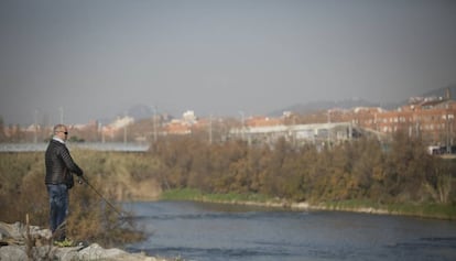 Un vecino pesca en el tramo del río Besòs correspondiente a Santa Coloma y Barcelona, cerca de su desembocadura