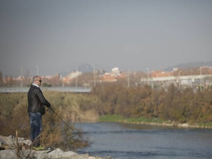 Un vecino pesca en el tramo del río Besòs correspondiente a Santa Coloma y Barcelona, cerca de su desembocadura