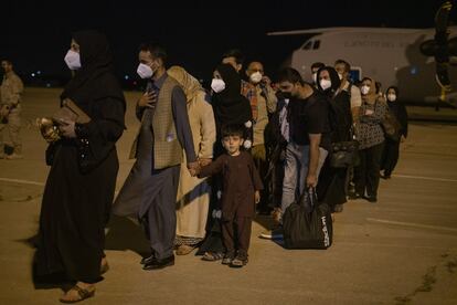 Los primeros refugiados evacuados de Afganistán bajan del avión, este jueves de madrugada a su llegada a la base de Torrejón de Ardoz (Madrid).
