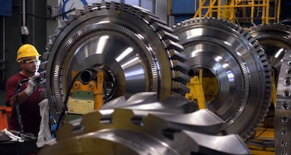 Un empleado trabaja en el rotor de una turbina de gas en la fábrica de Siemens en Berlín.