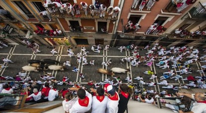 El público contempla desde los balcones el séptimo encierro de los sanfermines.