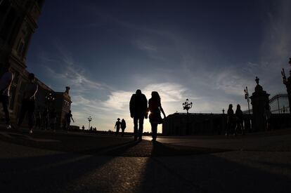 Varias personas pasean el sábado por las inmediaciones del palacio Real, en Madrid.