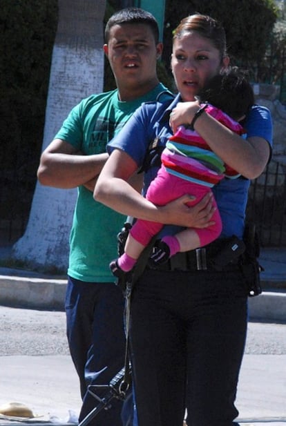 Una agente de policía lleva en brazos al bebé de tres meses que viajaba en el vehículo de la pareja de estadounidenses asesinados en Ciudad Juárez.