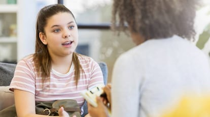 Una orientadora atiende a una alumna adolescente.