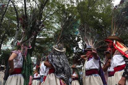 Mujeres con vestimenta tradicional, pasamontañas y sombreros adornados con plumas de pavorreal, fotografiadas durante la marcha.