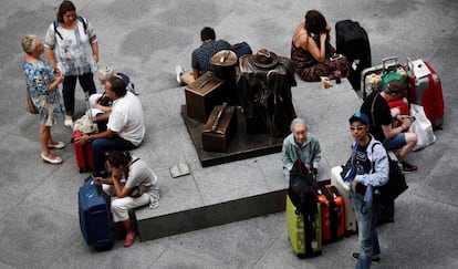 Una decena de viajeros espera en la estación de Atocha de Madrid.