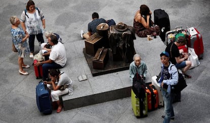 Una decena de viajeros espera en la estación de Atocha de Madrid. 