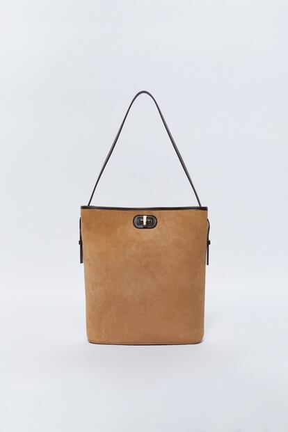 Sfera propone una apuesta segura de estilo con este bolso en piel de efecto ante de color beige ribeteado en cuero negro. Perfecto para llevarlo con todo. 32,99 euros.