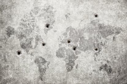 Agujeros de bala en una pared con un mapa del mundo.