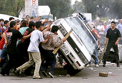 Un grupo de manifestantes vuelca un coche de la policía en San Salvador Atenco, cerca de la capital mexicana.