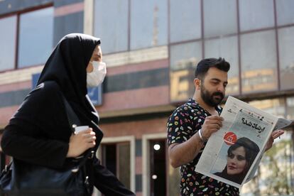 Un hombre leía el lunes en Teherán un periódico en el que figura la fotografía de Mahsa Amini.