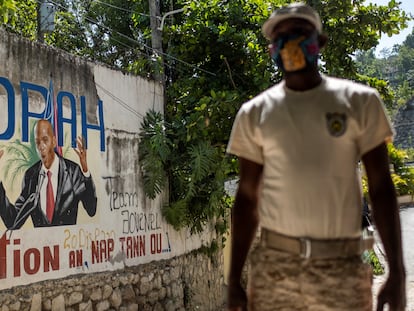 Policial monta guarda em 11 de julho diante de um mural que mostra o presidente haitiano Jovenel Moise na entrada da casa onde foi assassinado, em Porto Príncipe.