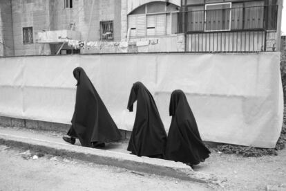 Tres mujeres judías ultraortodoxas haredim (temerosos de Dios, como se denomina a los ultraortodoxos) ataviadas con el "frumka", pasean por Jerusalén (Israel).