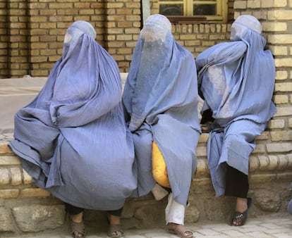 Tres mujeres con burka esperan para recibir ayuda de un programa de alimentación que organiza la ONU para repartir comida a personas necesitadas durante el Ramadán, en Afganistán. 16 de julio de 2014.