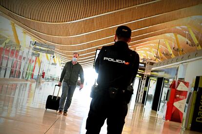 Un policía controla el acceso a la T-4 del Aeropuerto Adolfo Suárez Madrid-Barajas, el viernes 10 de octubre, para vigilar el cumplimiento de las restricciones a la movilidad impuestas por el estado de alarma en Madrid que decretó el Gobierno.