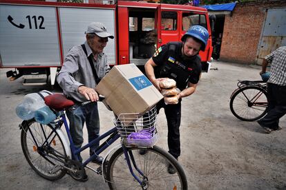 Firefighters distribute humanitarian aid among the few residents who remain in Orikhiv.