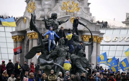 Varios manifestantes se encaraman a un monumento en la plaza de la Independencia, bautizada por el movimiento opositor como 'euromaidán' (plaza de Europa).