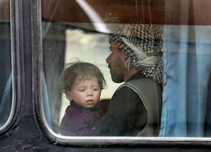 Una niña mira por la ventanilla del autobús que va a evacuar a un grupo de civiles de Guta Oriental (Siria). 