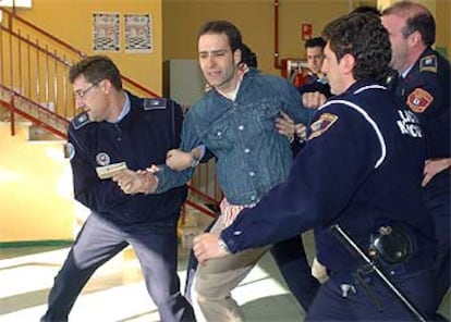 Un joven es desalojado por agentes de la Policía Municipal tras increpar al candidato del PP Mariano Rajoy a su salida del colegio Bernardette de Aravaca (Madrid), al que acudió a votar.