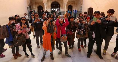 Un grupo de turistas fotograf&iacute;a la Alhambra.