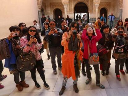 Un grupo de turistas fotograf&iacute;a la Alhambra.