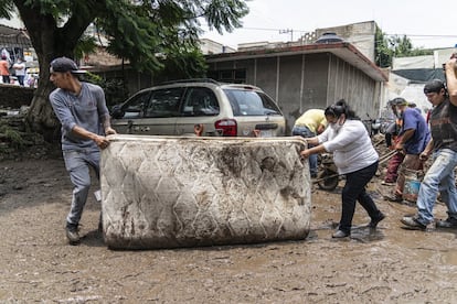 Voluntarios sacan un colchón dañado de un domicilio en Atizapán, el 6 de julio.
