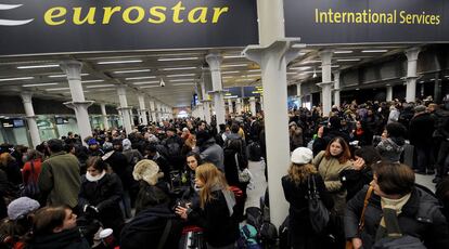 Pasajeros en la estación  de King Cross esperan a que se restablezca el servicio de ferrocarril en el Eurotúnel, ayer en Londres.