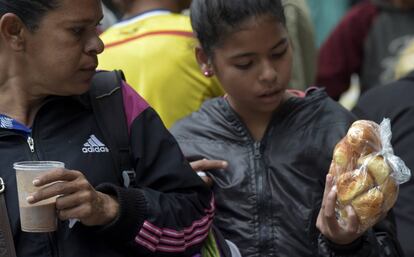 Migrantes venezolanos reciben una donación de comida en un campamento improvisado en Bogotá, Colombia.