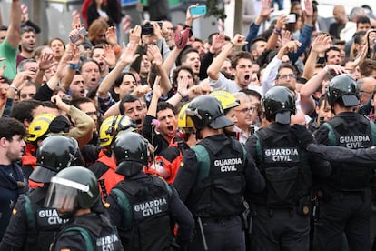 Firefighters place themselves between protesters and Civil Guard riot officers outside a polling station in San Julià de Ramis, Catalonia.